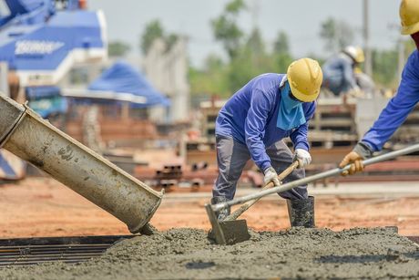 guys spreading concrete for a commercial building