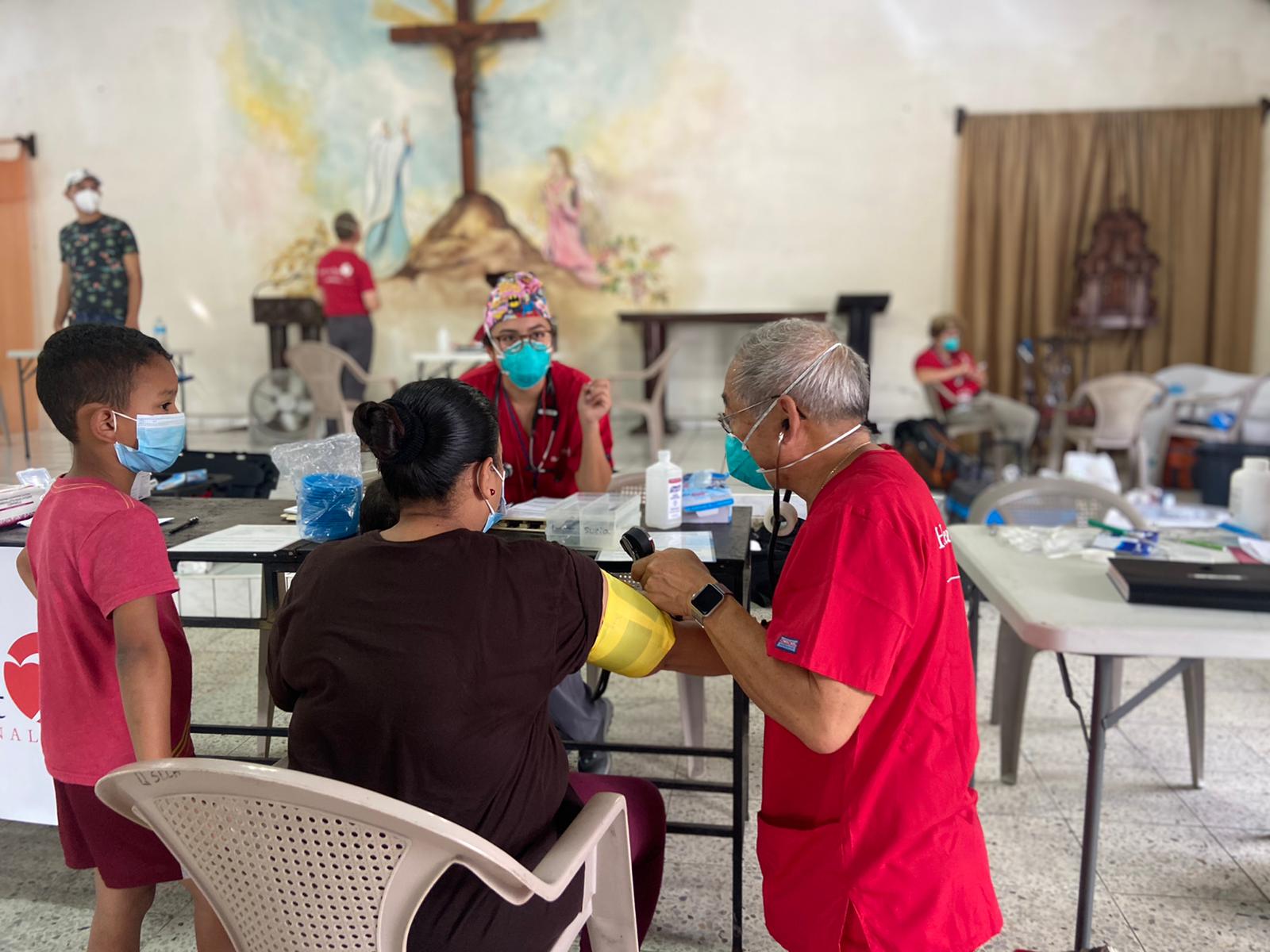 people in masks around a table with medical supplies