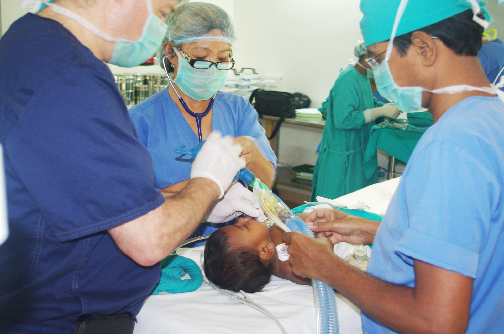 A group of doctors are working on a child in an operating room