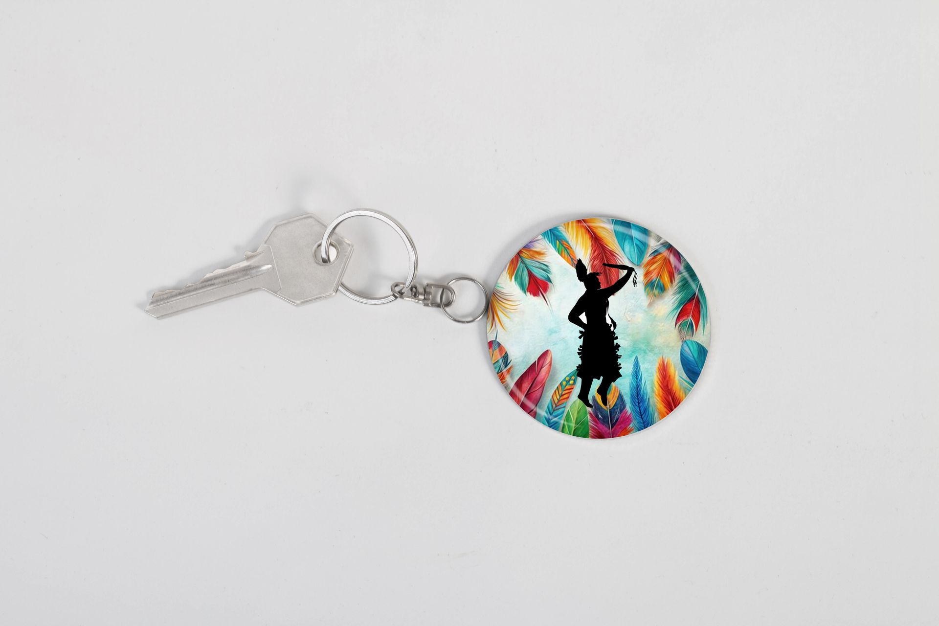 A key chain with a picture of a indigenous woman dancing on it.