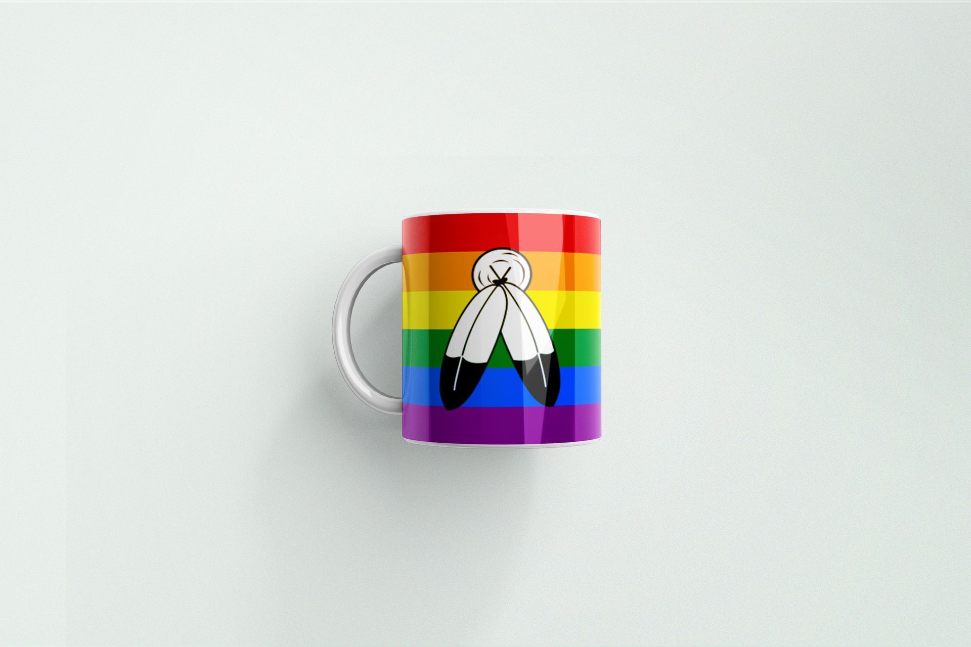 A mug with a rainbow flag on it is sitting on a white surface.