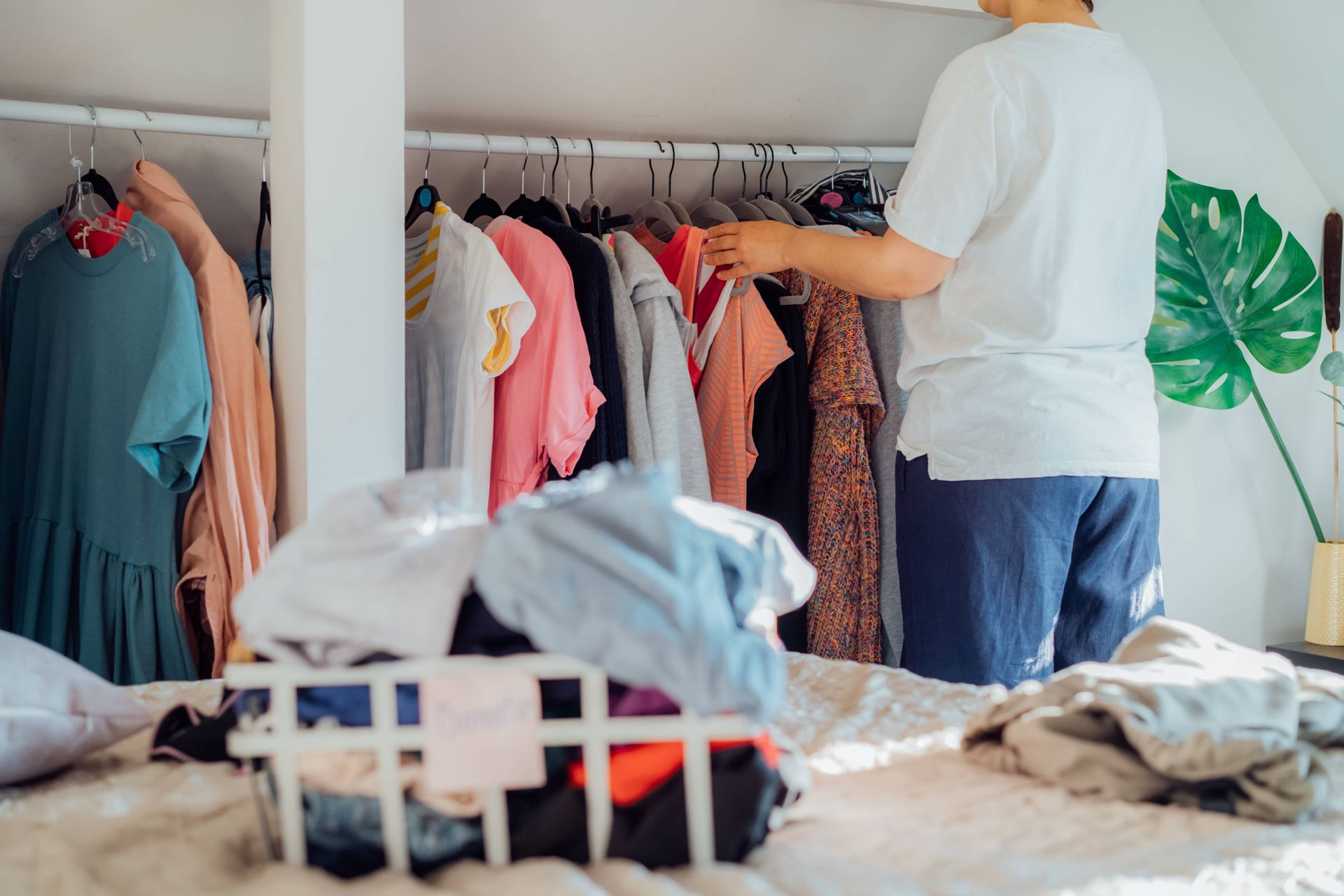 A woman is standing in front of a closet full of clothes.