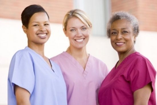 Three nurses are posing for a picture together and smiling