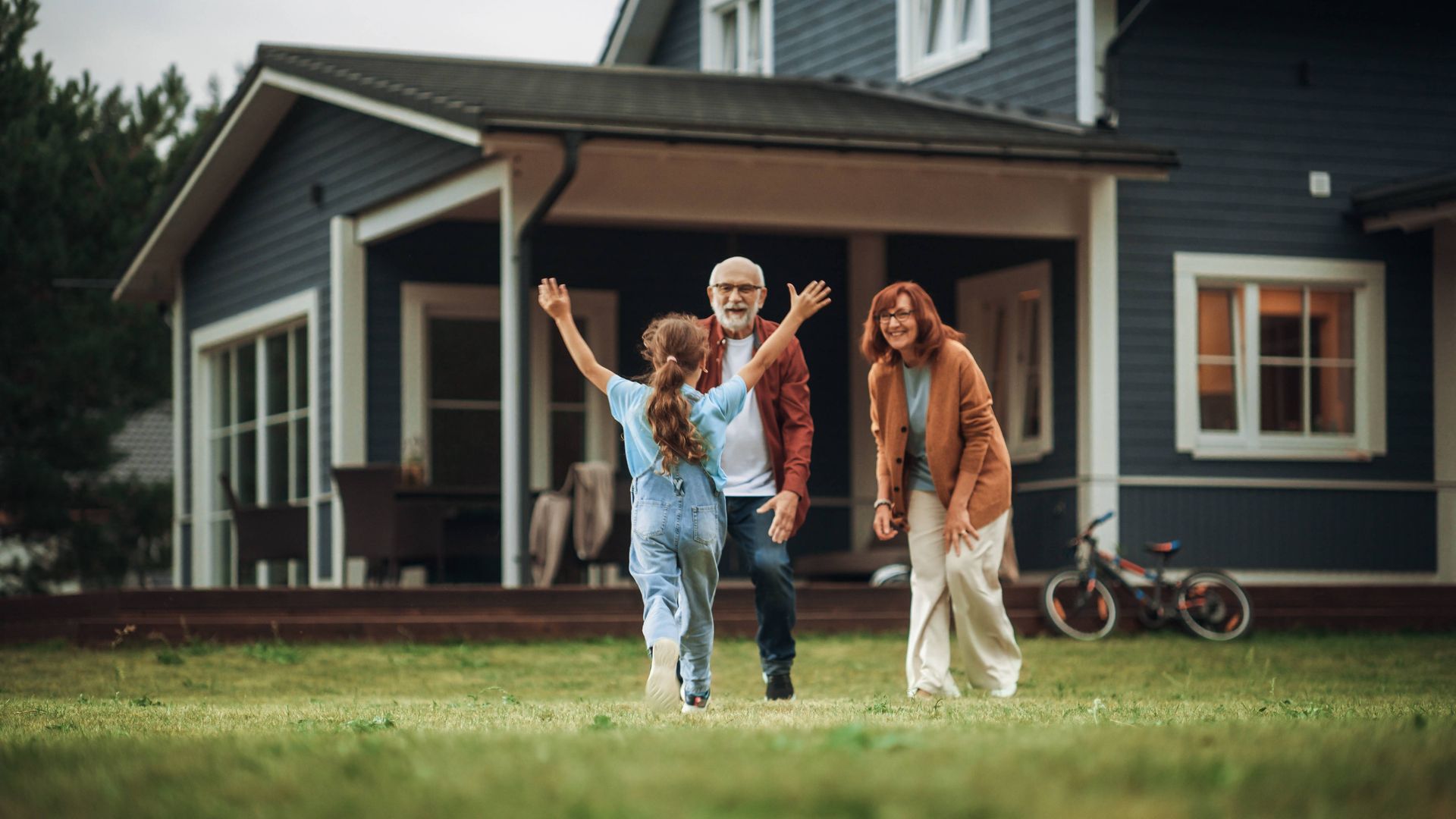 A family is standing in front of a house.