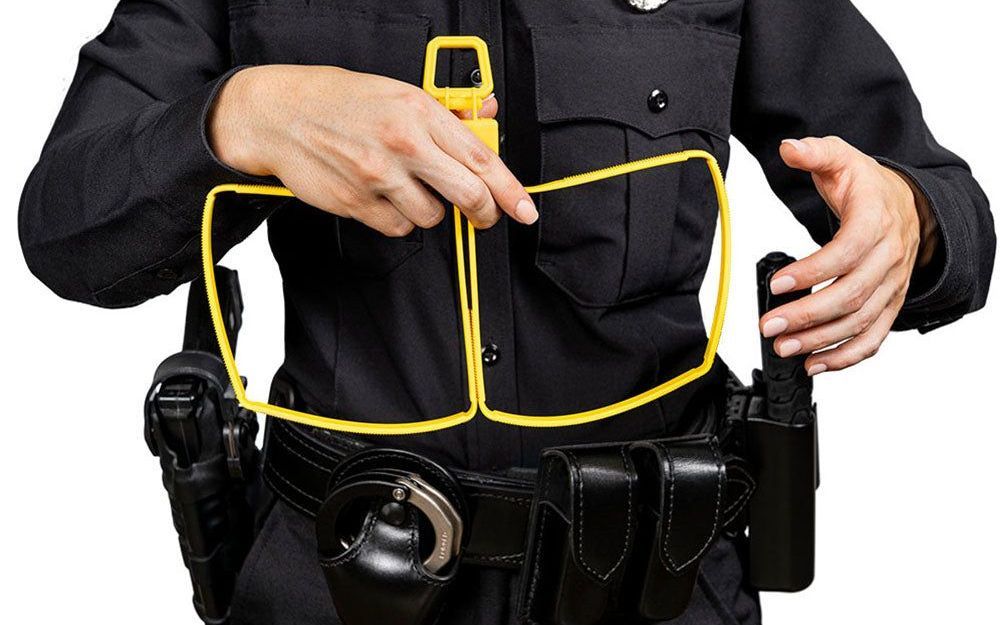 A police officer is holding a pair of yellow glasses