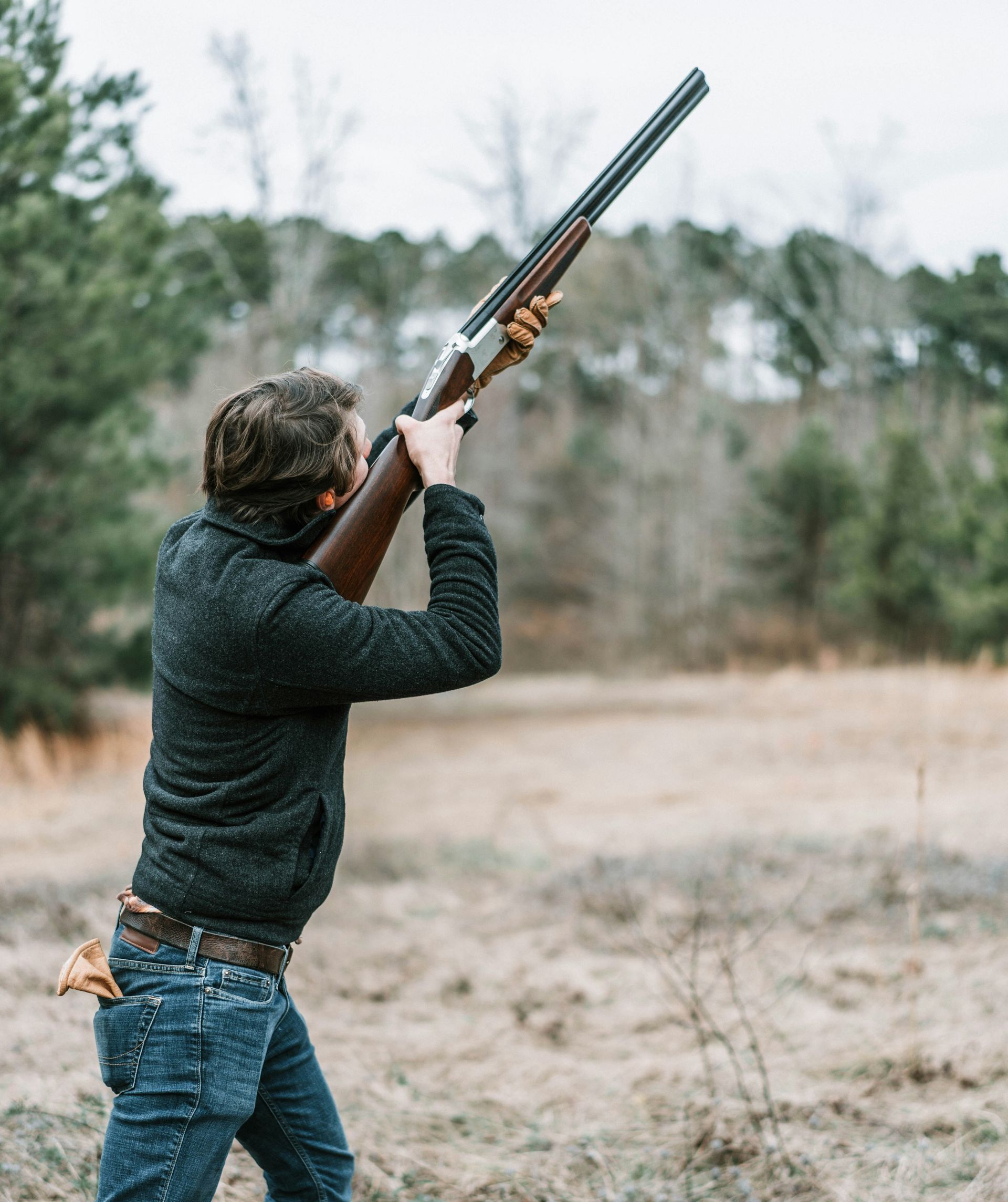 man shooting shotgun