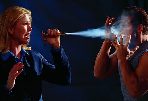 woman spraying pepper spray at a man