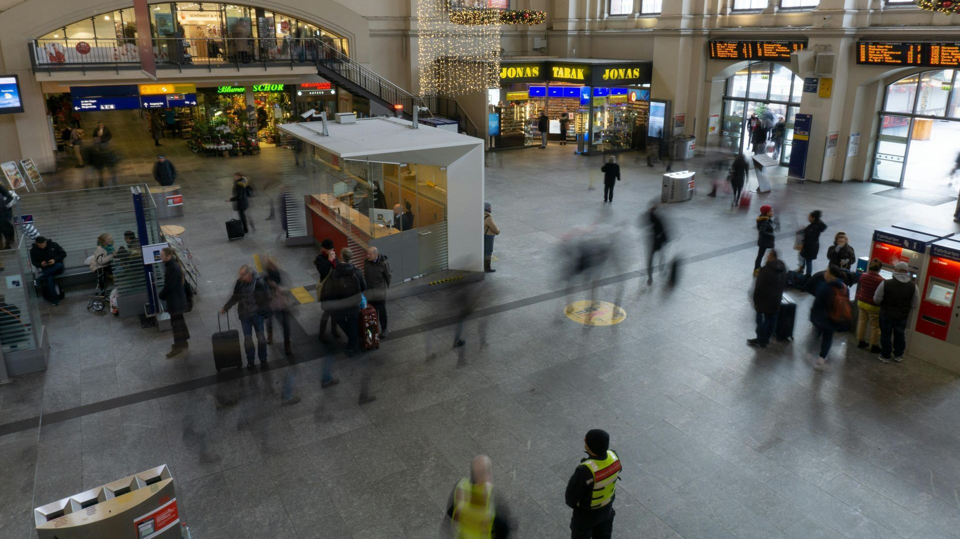 A blurry picture of a train station with people walking around