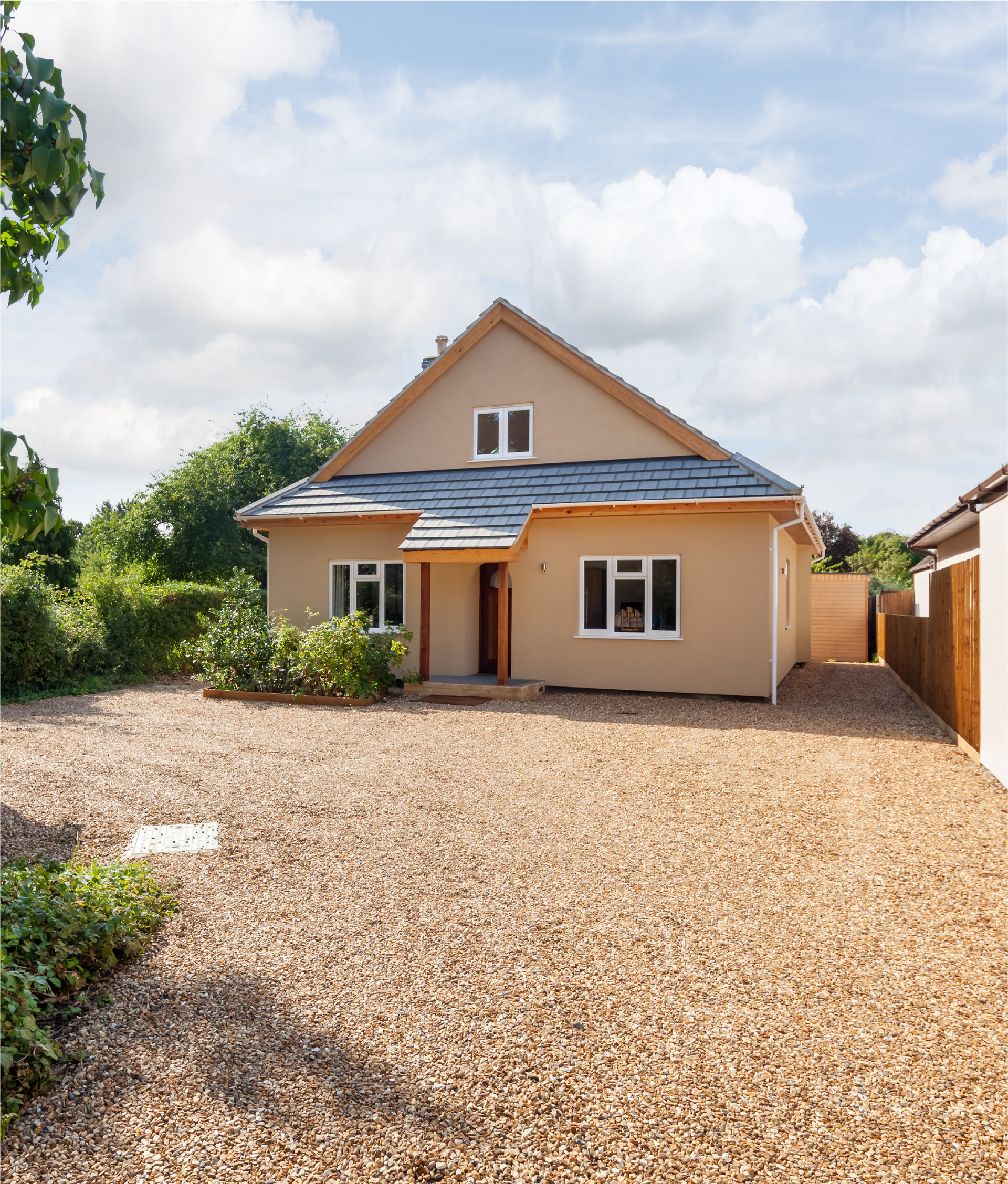 A house with a gravel driveway in front of it