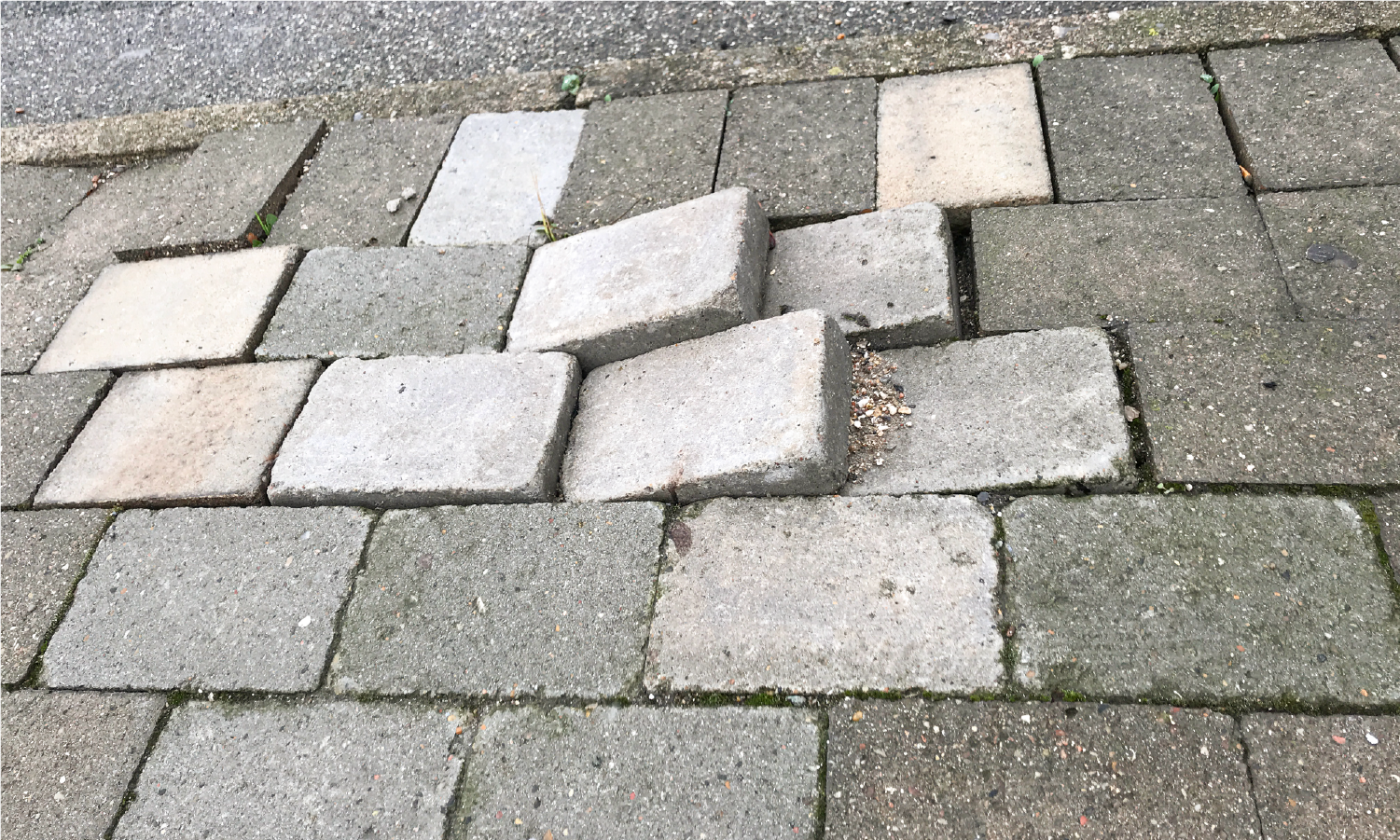 A pile of bricks laying on top of each other on a sidewalk.