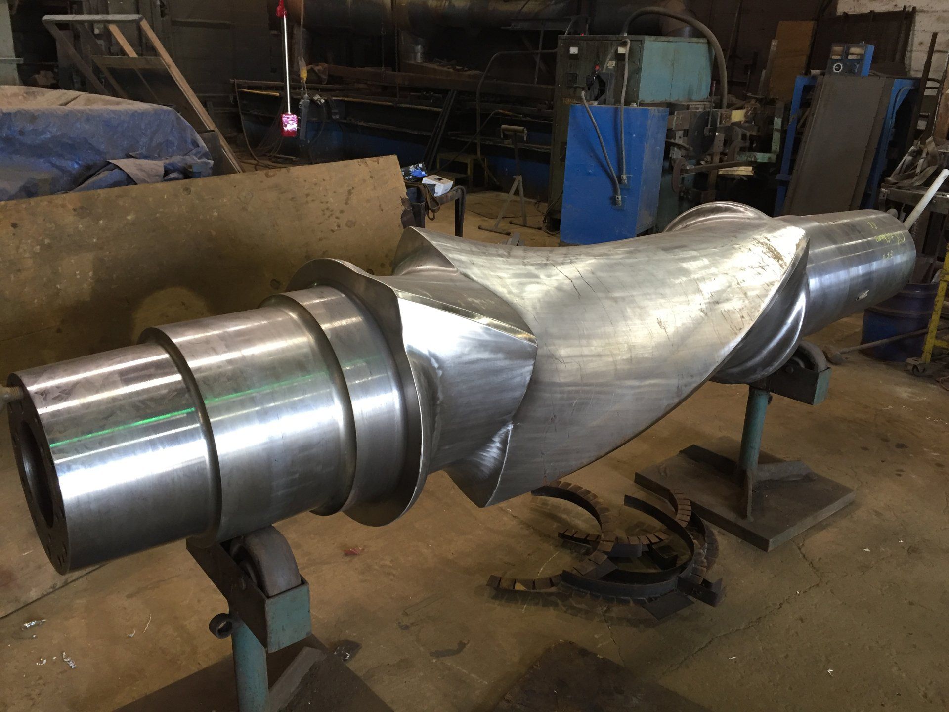 a large metal object is sitting on a stand in a factory
