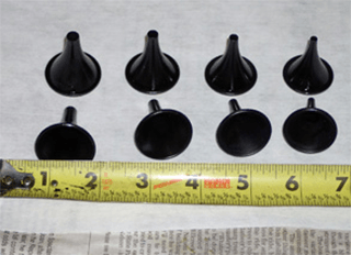 a yellow tape measure is next to a bunch of black plastic funnels