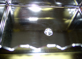 a close up of a metal surface with a hole in it .