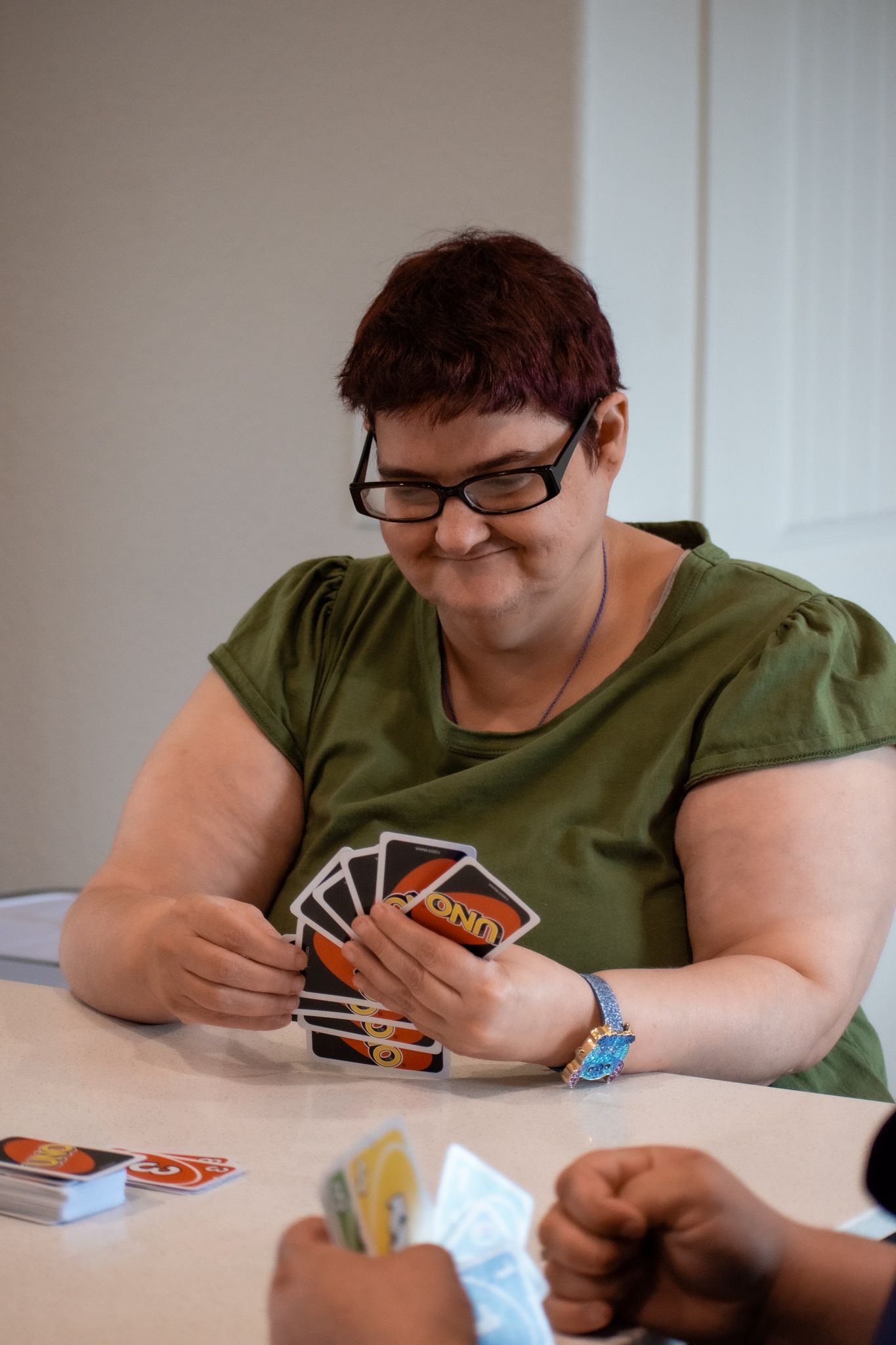 Image by Essential Living Support, LLC photo of clients playing card games with provider.