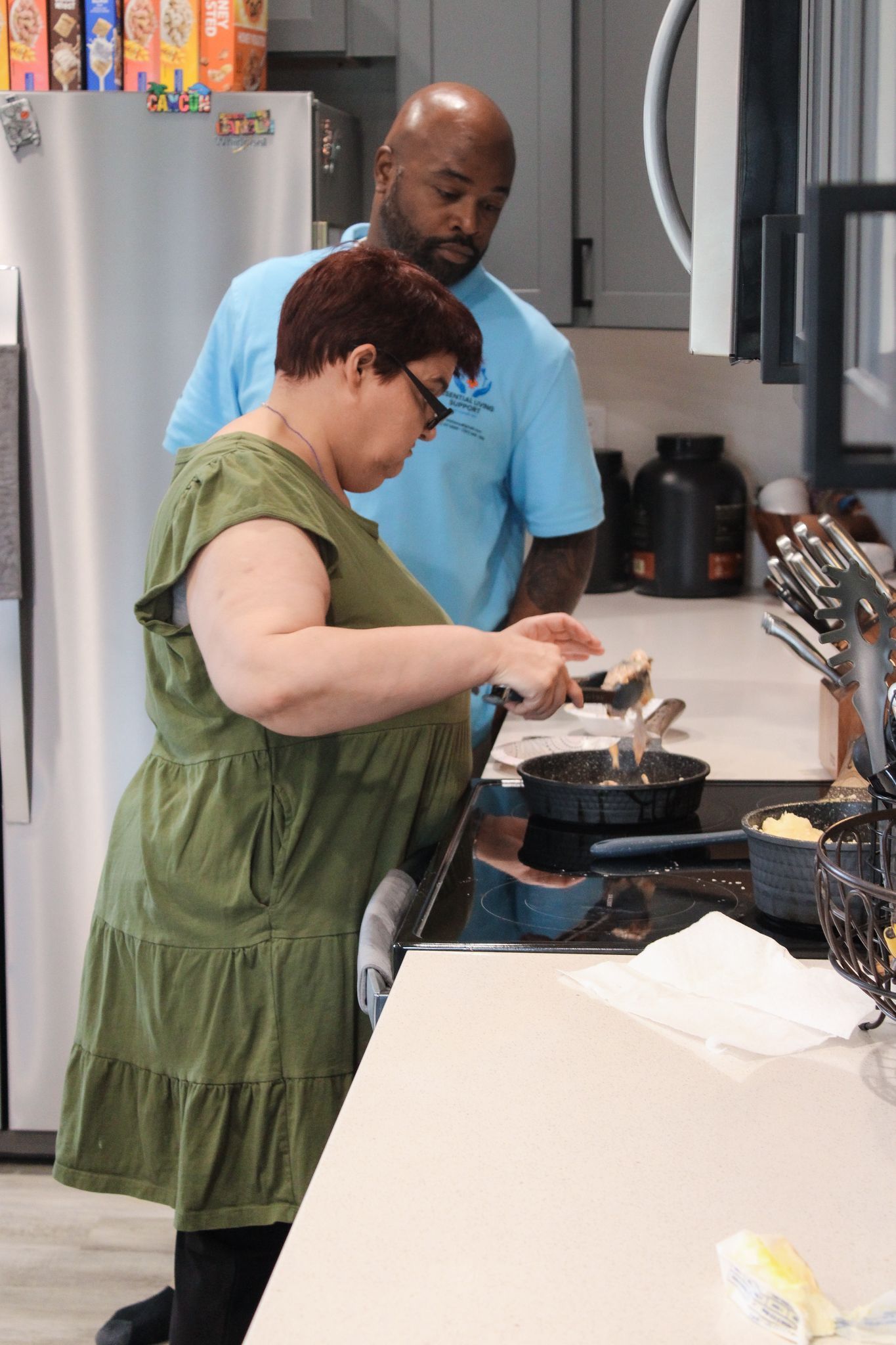 Caregiver assisting an older adult in the kitchen, in home support