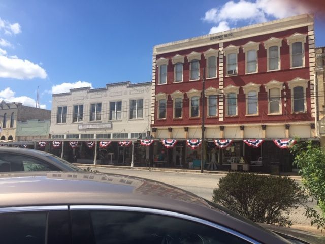A car is parked in front of a row of buildings.