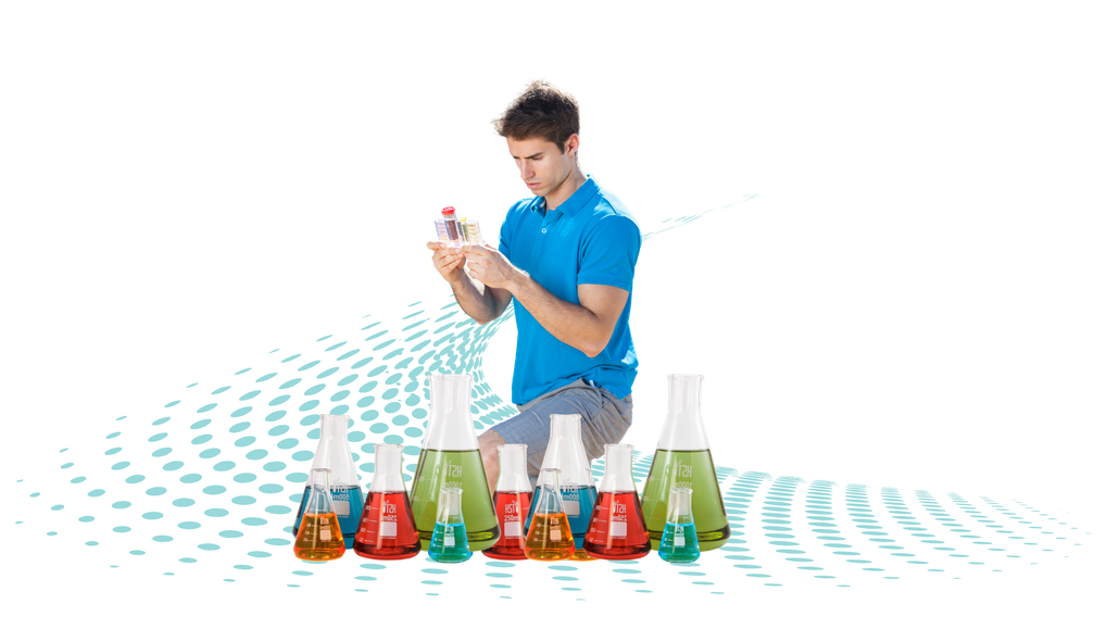 A man is kneeling down in front of a row of test tubes.