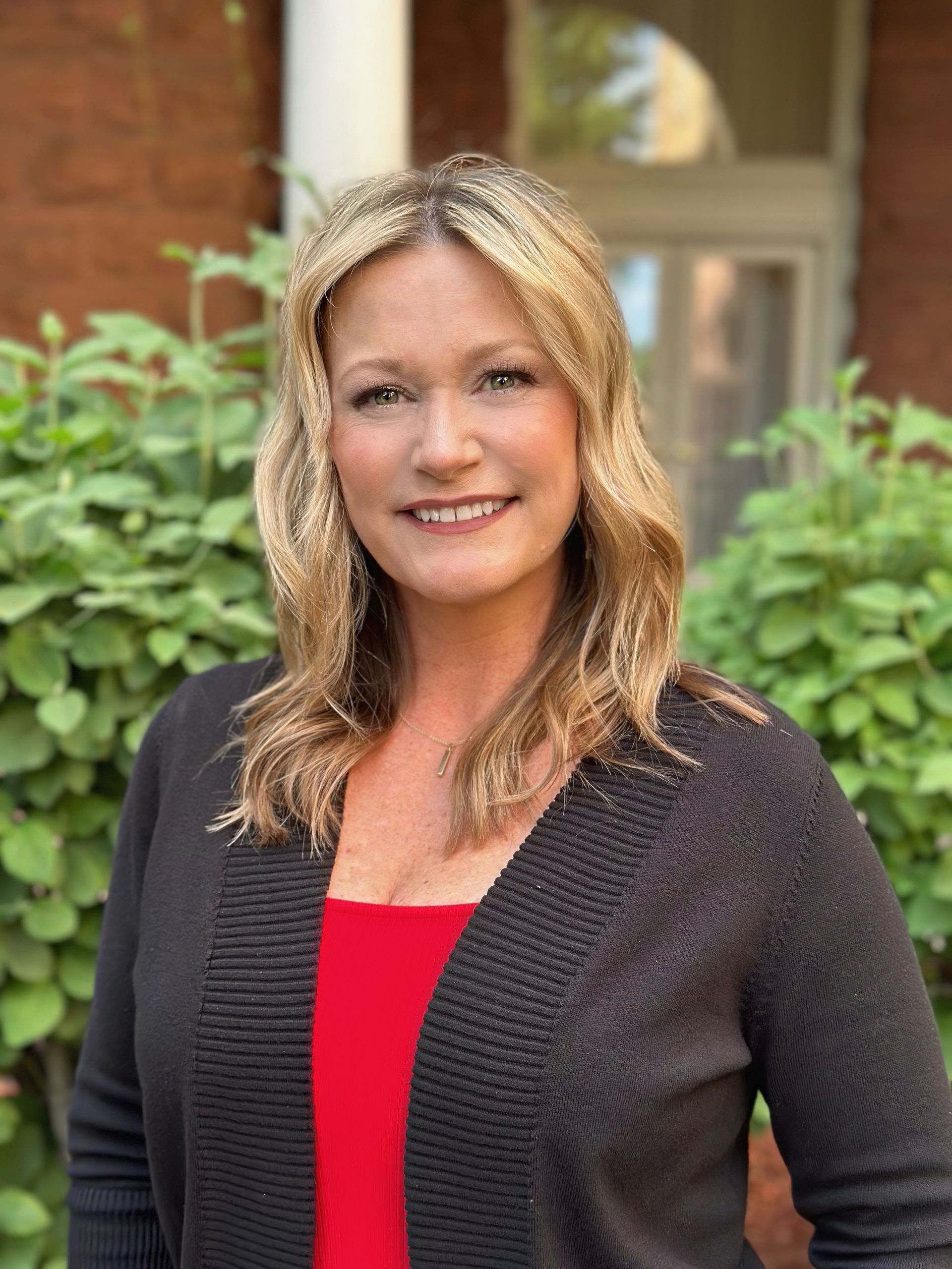 A man and a woman are sitting on a dock overlooking a lake.