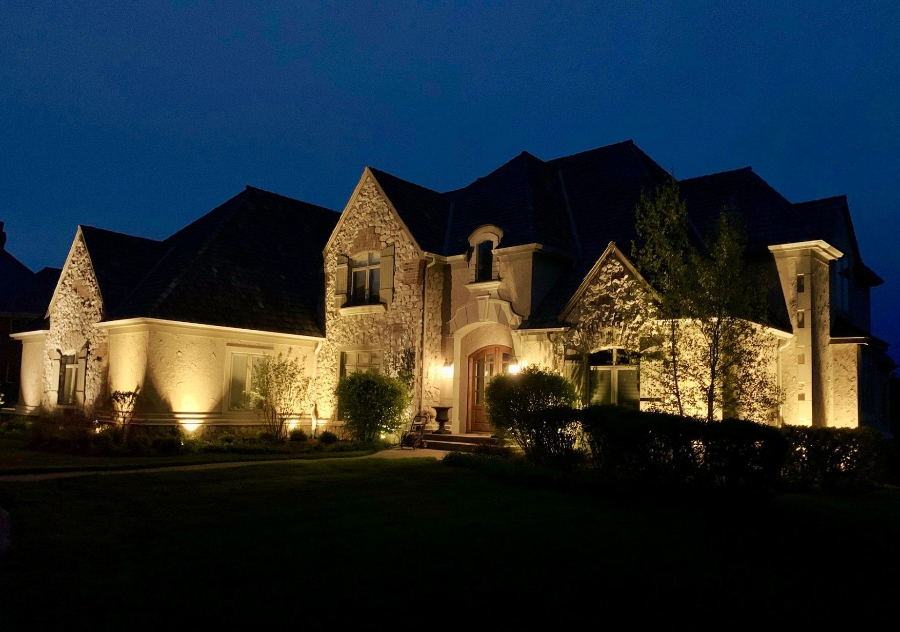 A large brick house is lit up at night