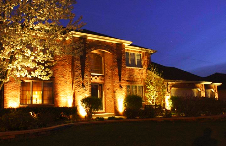 A large brick house is lit up at night