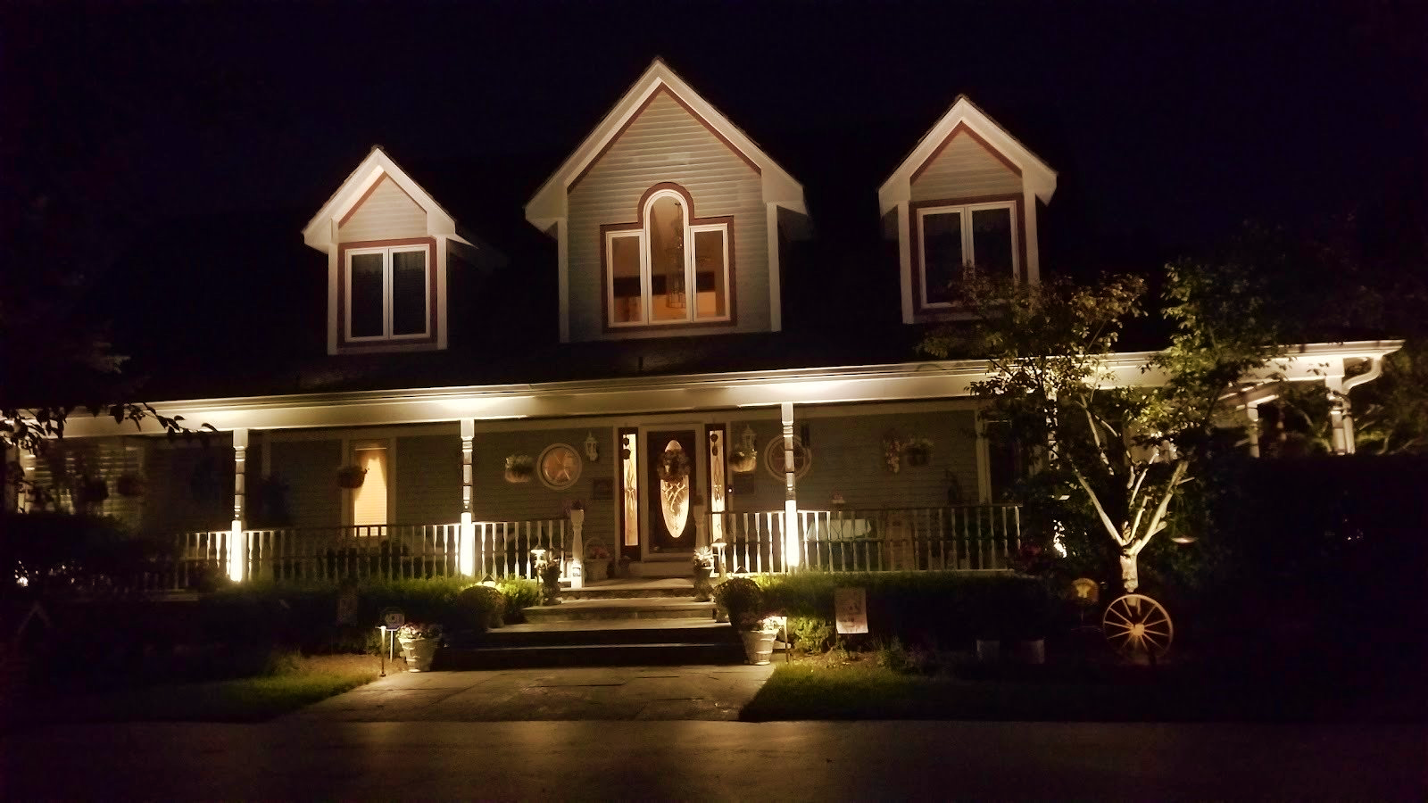 The front of a house is lit up at night.