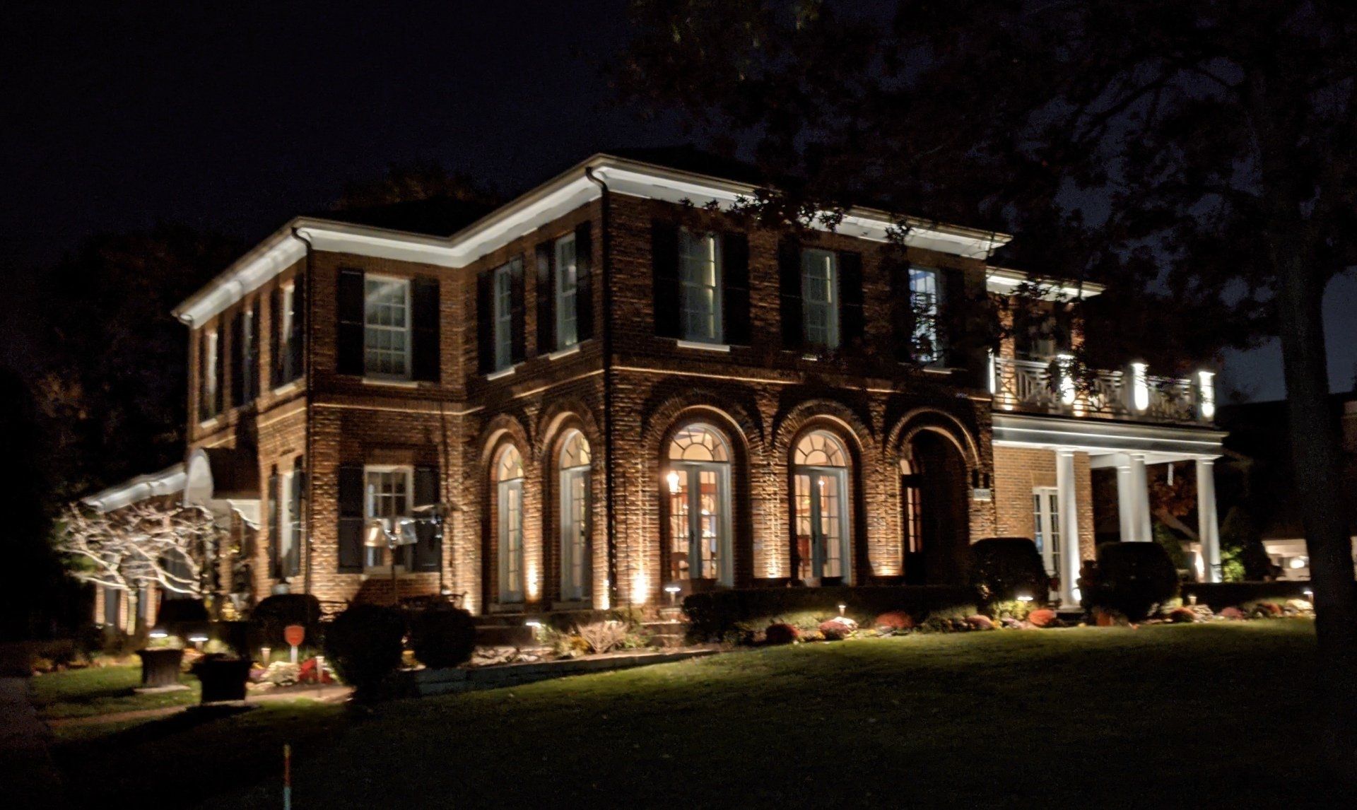 A large brick house is lit up at night.