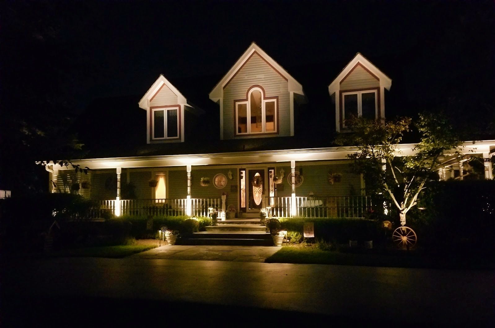 The front of a house is lit up at night.