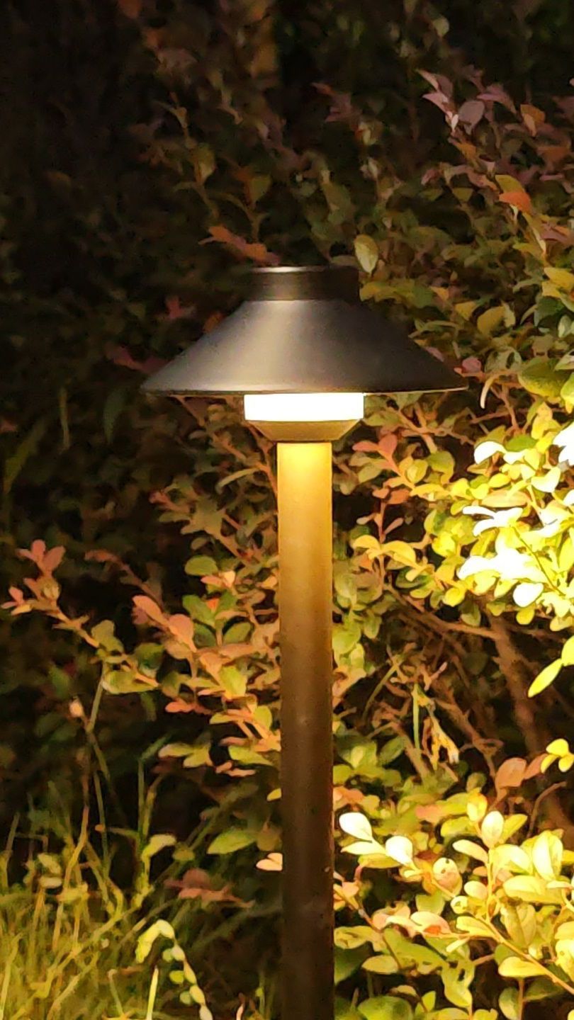 A brass light with a brown shade on a background.