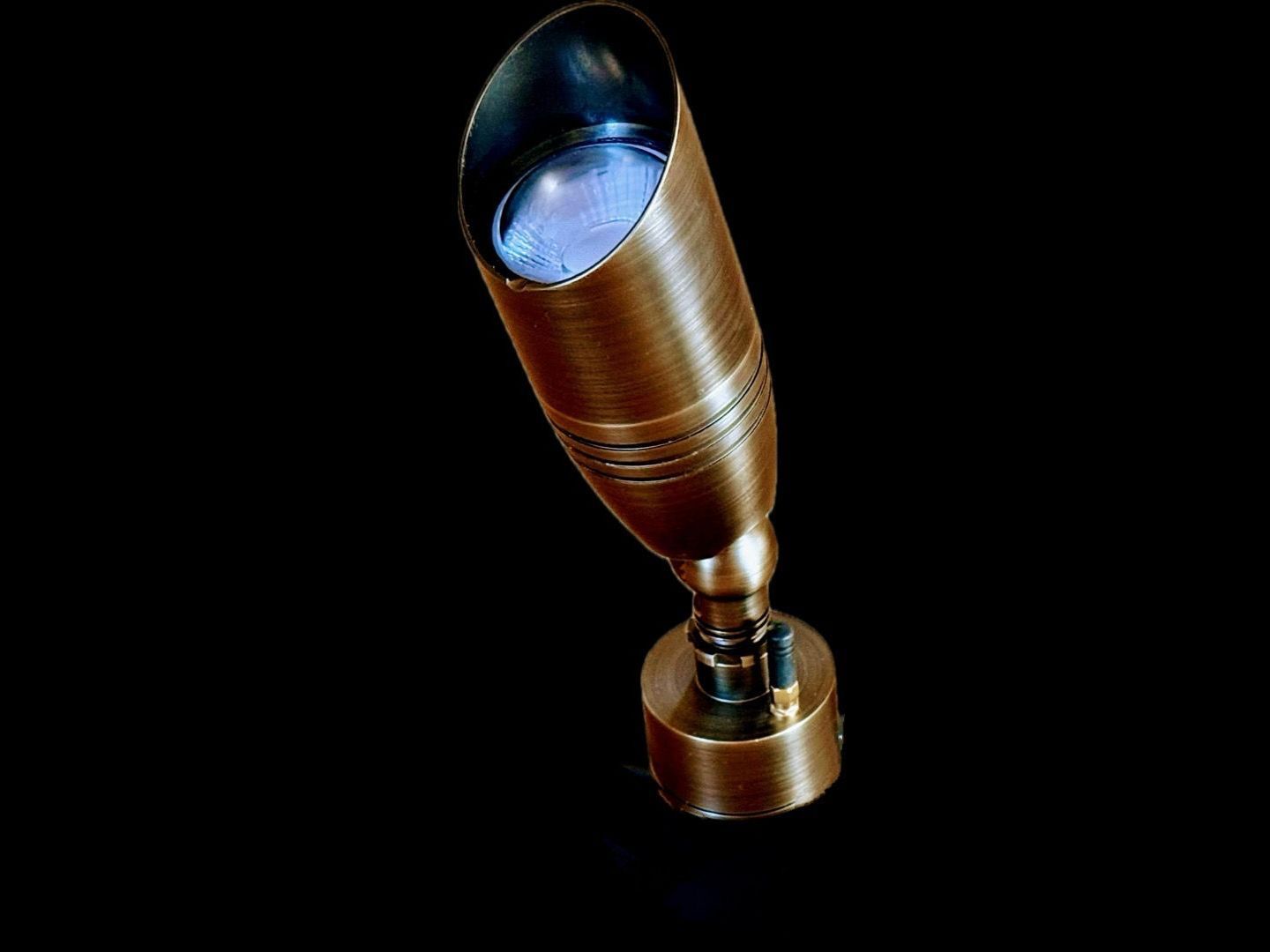 A brass object with a light inside of it on a black background