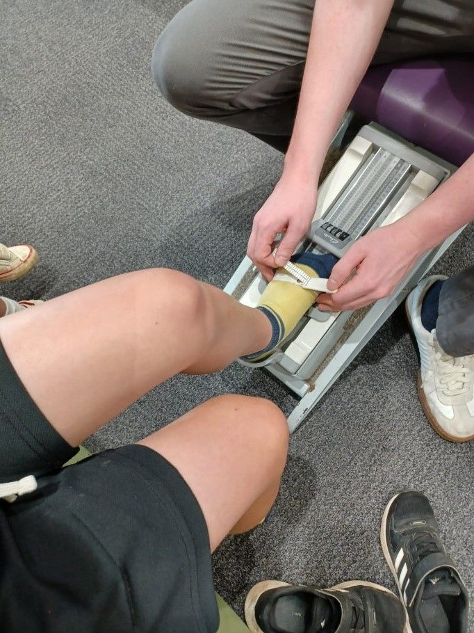 A person is getting their feet measured by a doctor