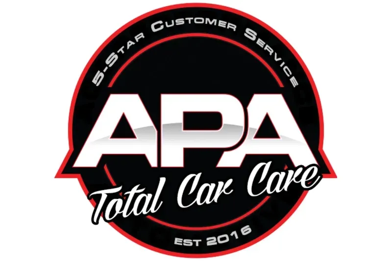 Logo for APA Total Car Care: a black circular emblem with red trim featuring bold white text and