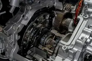 A close-up view of the metallic internal gears, clutches, and housing components of an automotive transmission system.