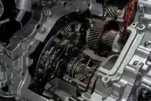 A close-up view of the metallic internal gears, clutches, and housing components of an automotive transmission system.