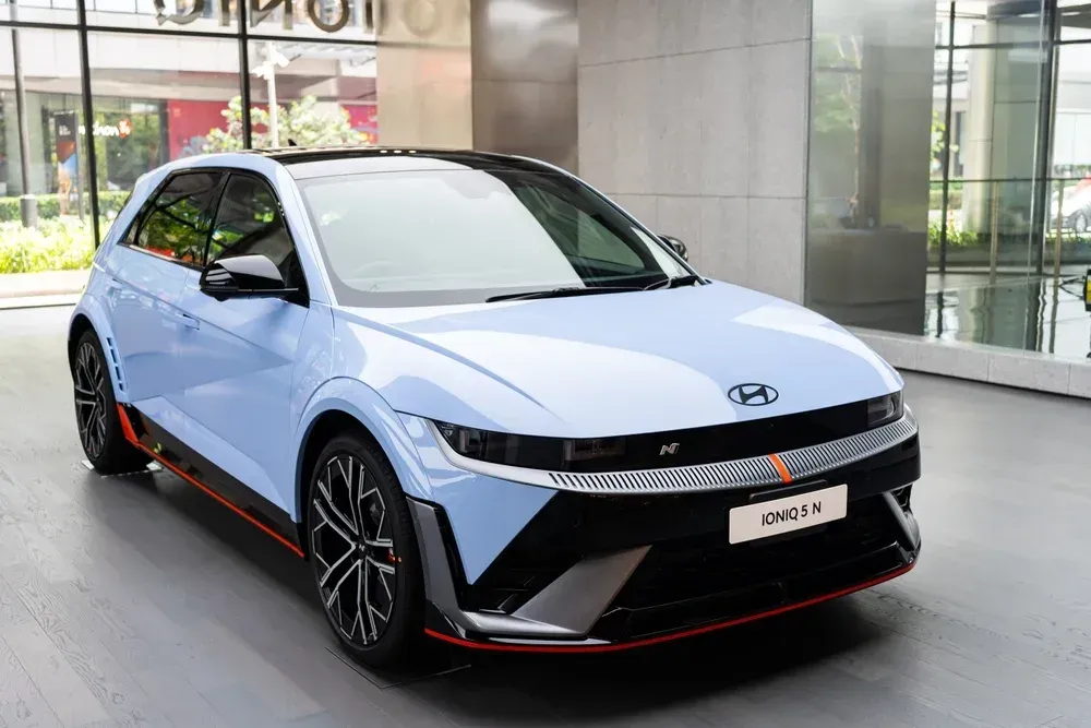 A light blue Hyundai Ioniq 5 N electric car with black and red accents parked on a polished floor in a modern showroom.