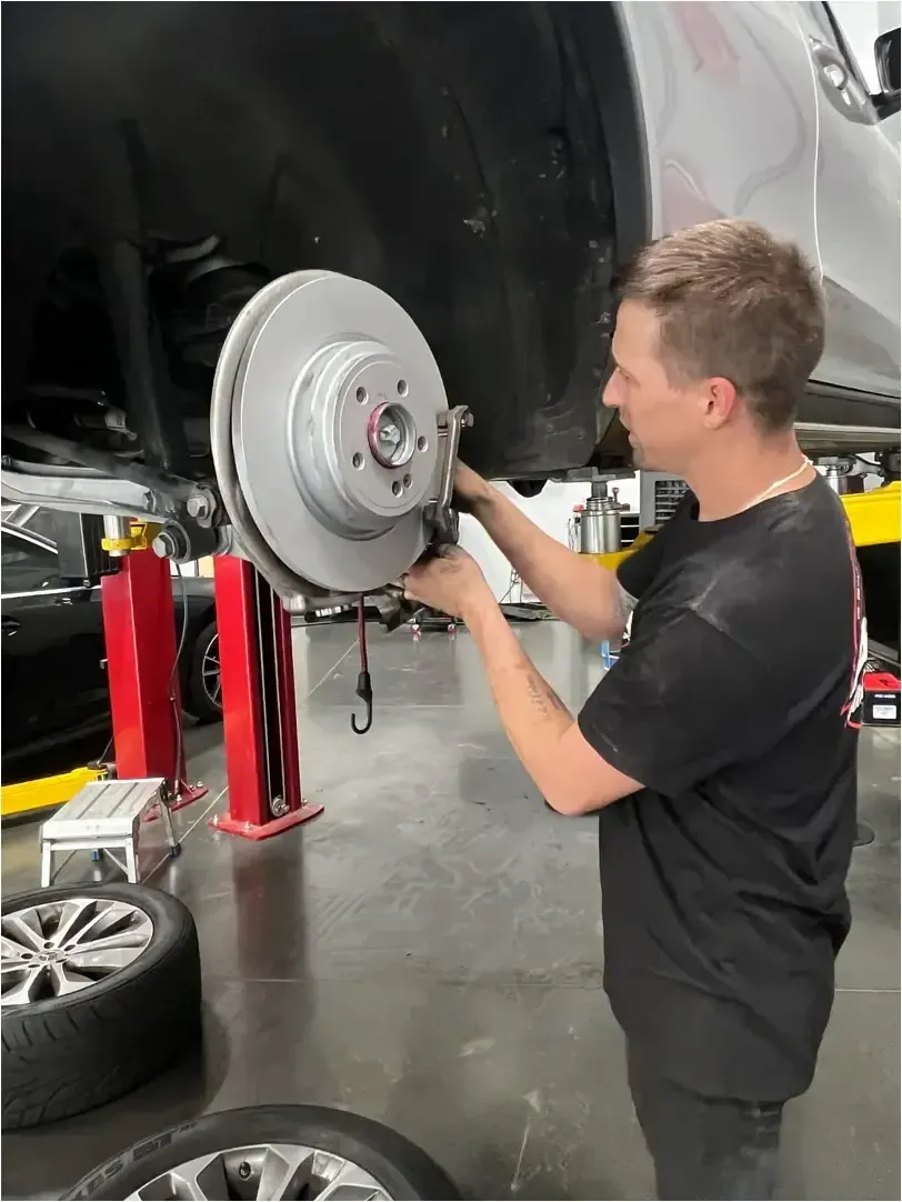 A mechanic in a black shirt labeled
