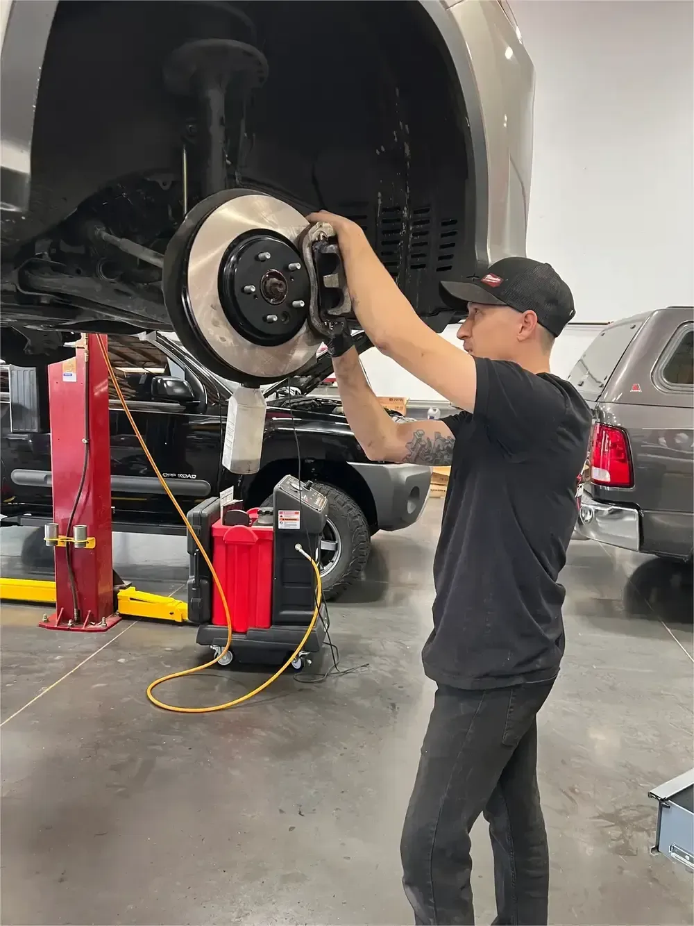 A mechanic in a black shirt labeled
