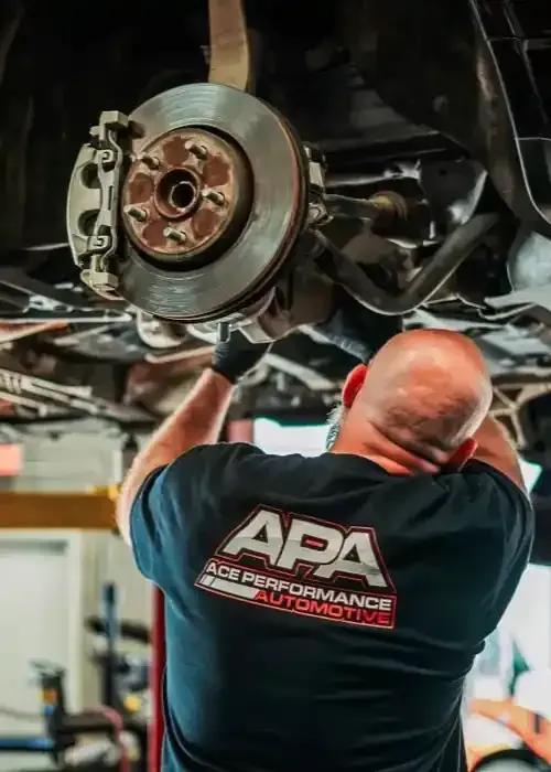 A mechanic in a black shirt labeled 