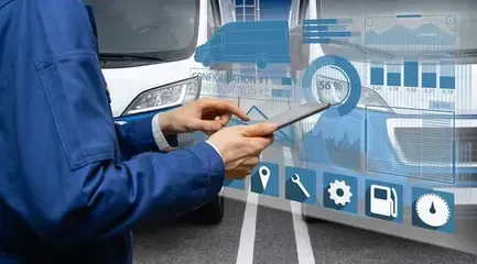 A technician in a blue uniform uses a digital tablet to interact with a holographic interface showing vehicle diagnostics.