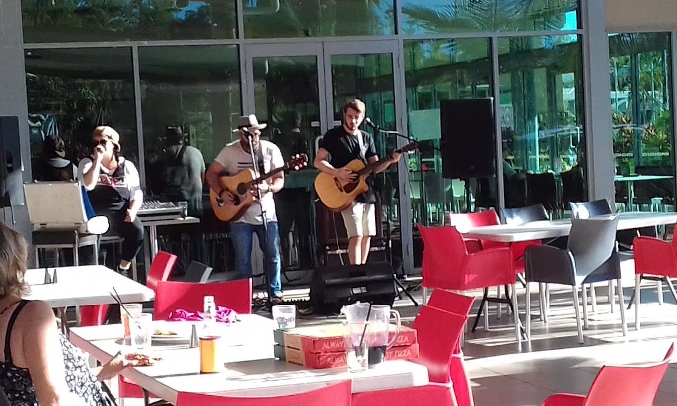 Band Playing Guitars Inside a Building With Large Windows — Capricorn Tavern in Taranganba, QLD