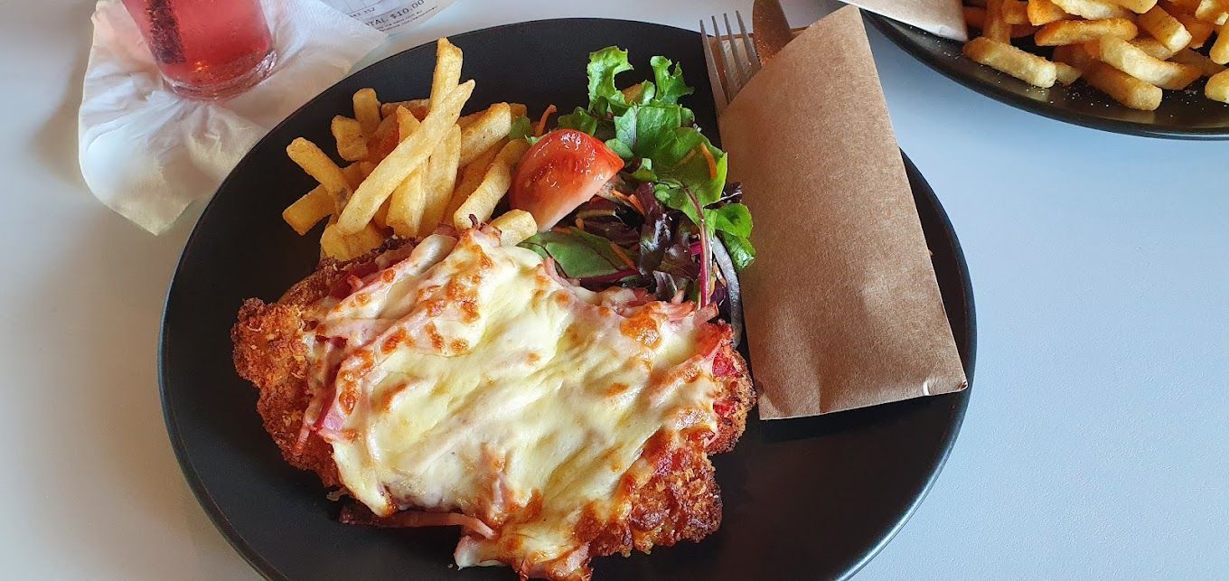 Plate With Schnitzel, Fries, Salad, and a Wrap — Capricorn Tavern in Taranganba, QLD
