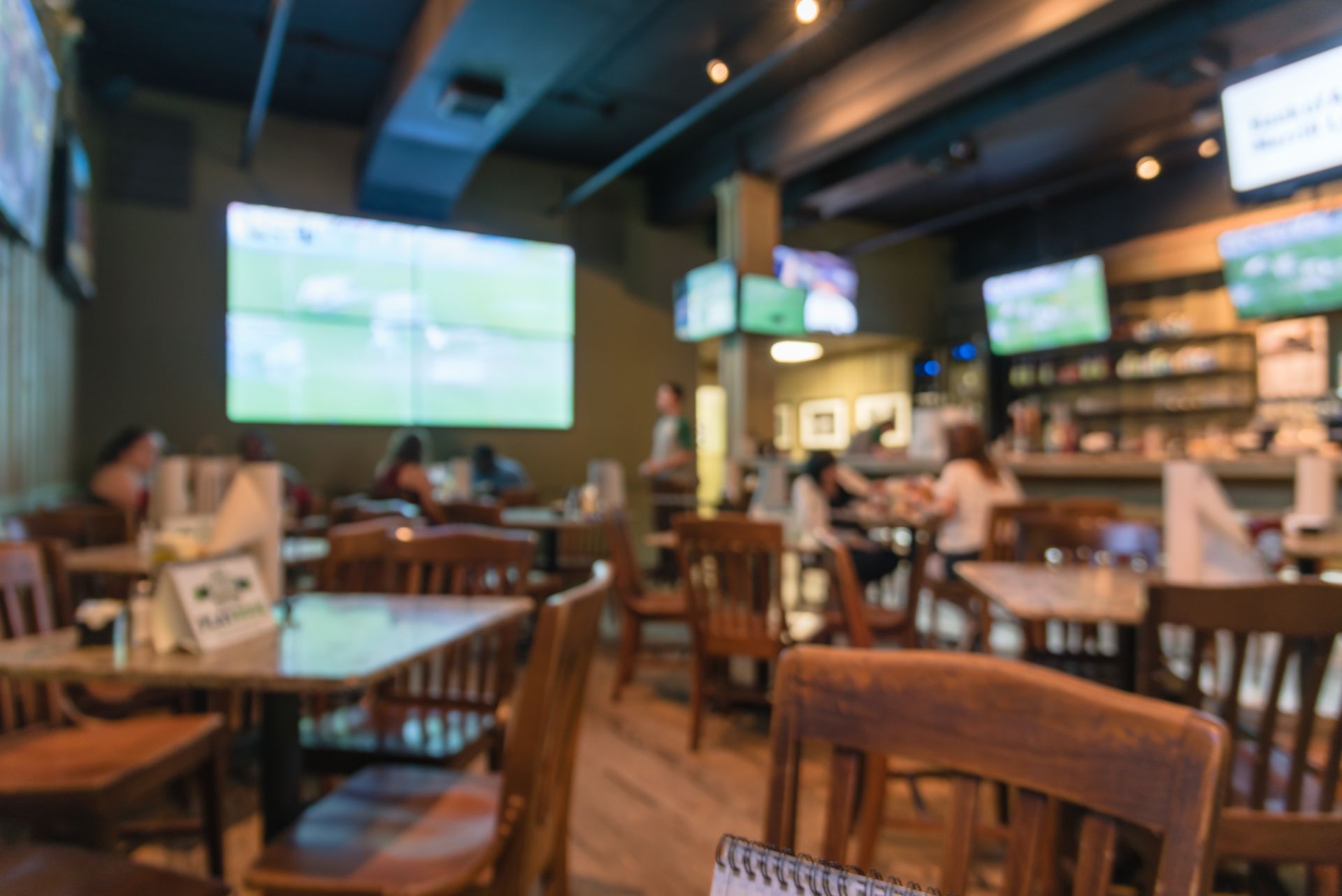 Interior of a Sports Bar With Wooden Tables and Chairs — Capricorn Tavern in Taranganba, QLD