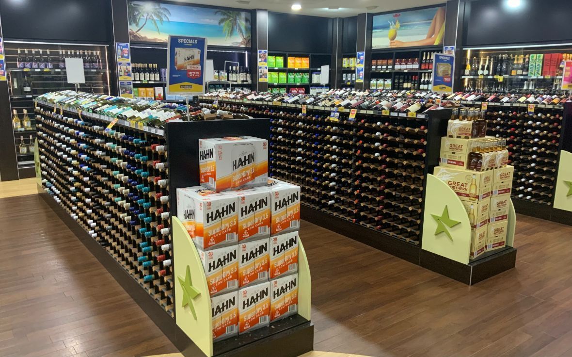 Liquor Store Interior With Rows of Wine Bottles and Stacked Boxes of Beer — Capricorn Tavern in Taranganba, QLD