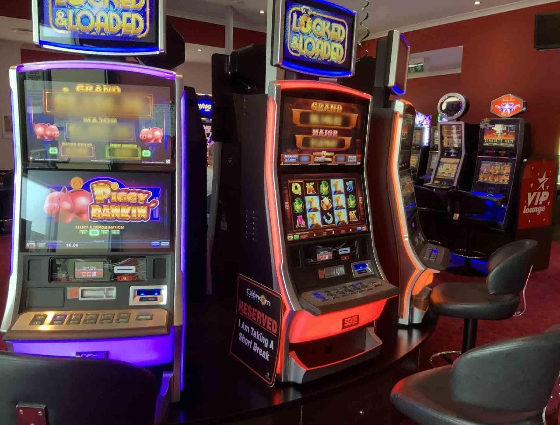 Slot Machines in a Dimly Lit Casino, Featuring Colorful Screens — Capricorn Tavern in Taranganba, QLD