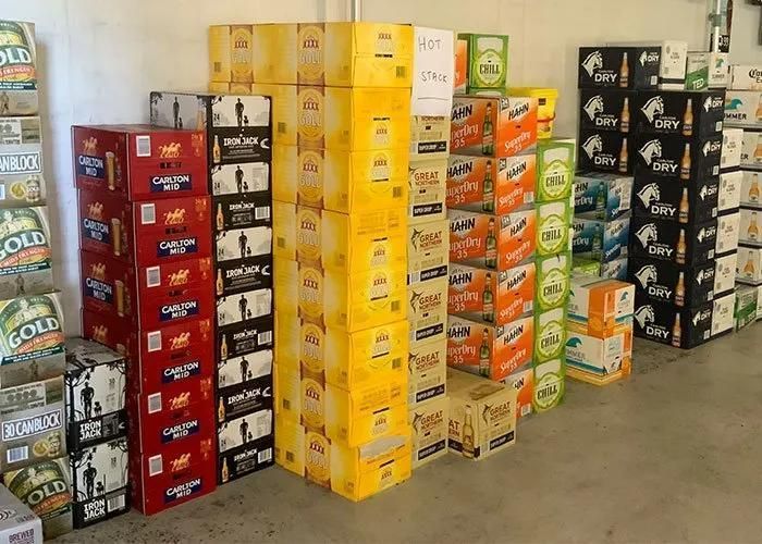 Stacks of Beer Cases in Various Colors Against a White Wall — Capricorn Tavern in Taranganba, QLD