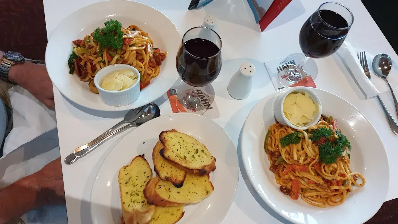 Four People Smiling and Talking at a Bar, Holding Glasses of Beer — Capricorn Tavern in Taranganba, QLD