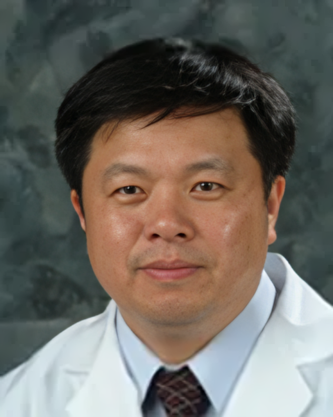 A man in a white coat and tie looks at the camera