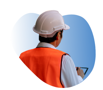 A man wearing a hard hat and safety glasses is working on an air conditioner.