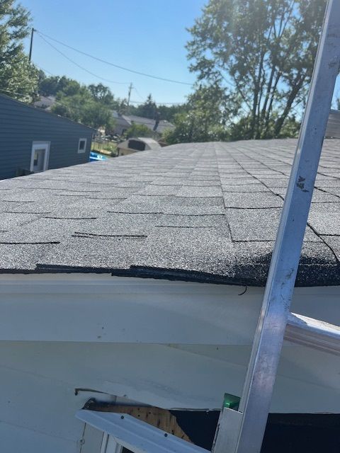 A close up of a roof with a ladder in the foreground