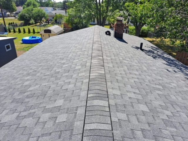 A roof with a chimney and a pool in the background