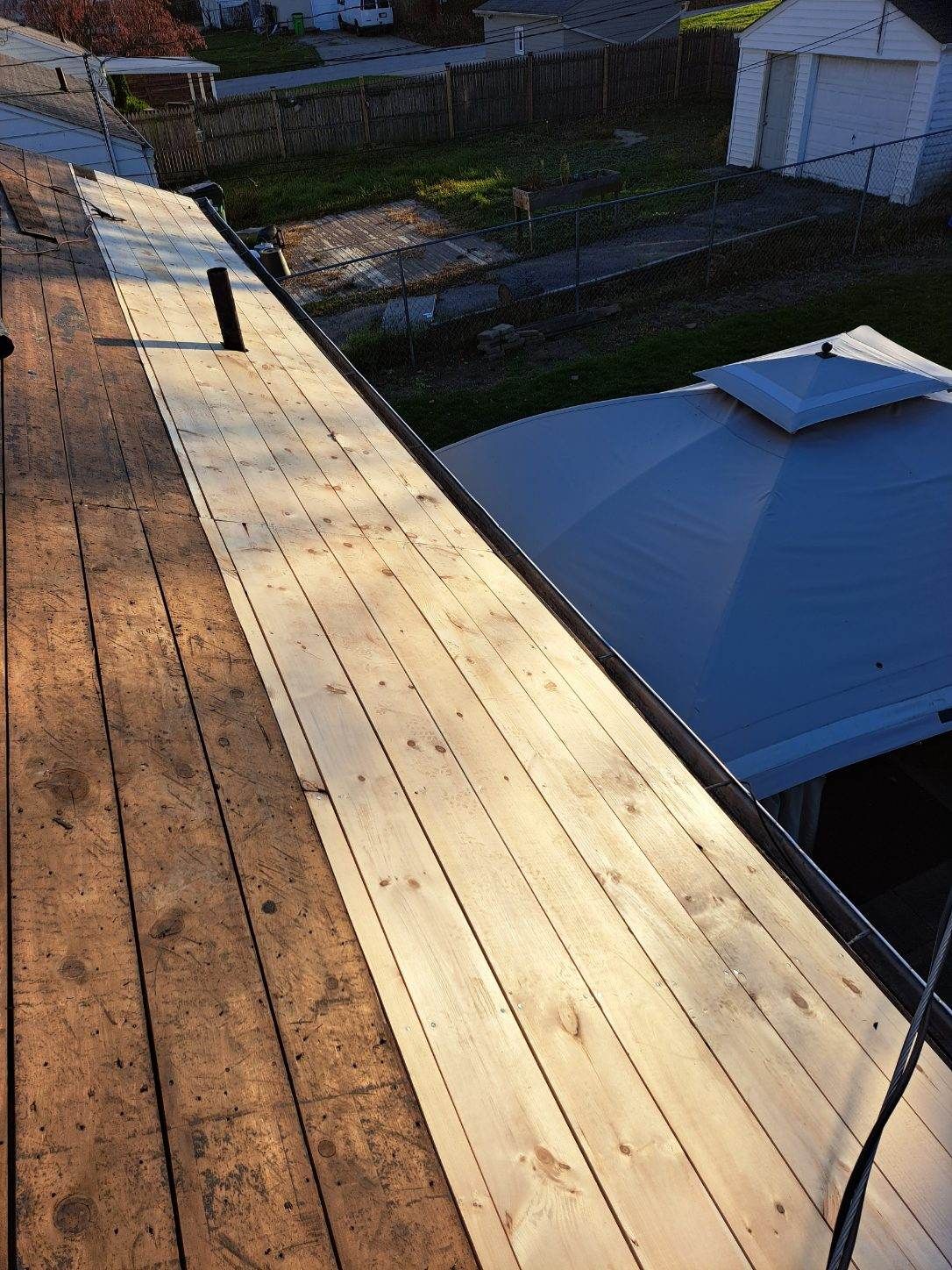 A wooden deck is being built on the roof of a house.